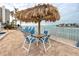 Inviting poolside seating area with a tiki umbrella, offering a relaxing spot with waterfront scenery at 6025 Shore S Blvd # 410, Gulfport, FL 33707