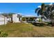 Lush backyard featuring an open green lawn, palm trees and a convenient storage shed at 6337 S Lansdale Cir, Tampa, FL 33616