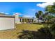 Landscaped backyard with open lawn, storage shed and mature palm trees on a sunny day at 6337 S Lansdale Cir, Tampa, FL 33616