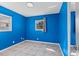 Bright bedroom with blue walls, tile flooring, and dual windows with outside views at 6337 S Lansdale Cir, Tampa, FL 33616