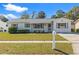 Charming one-story home featuring well-maintained landscaping, lush green grass, and bright exterior paint at 6337 S Lansdale Cir, Tampa, FL 33616