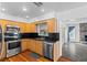 Well-lit kitchen features stainless steel appliances, wooden cabinets and black granite countertops at 6337 S Lansdale Cir, Tampa, FL 33616