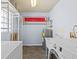 Functional laundry area includes washer, dryer, sink, water heater, and shelving at 6337 S Lansdale Cir, Tampa, FL 33616