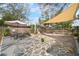 Beautiful backyard with a stone patio, shade sail, and space for relaxation and recreation at 6835 S Shamrock St, Tampa, FL 33616