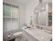 Modern bathroom with marble vanity, subway tile shower, and large window, offering a clean and bright space at 6835 S Shamrock St, Tampa, FL 33616