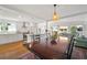 Open dining room featuring modern lighting, hardwood floors, and easy access to living room at 6835 S Shamrock St, Tampa, FL 33616