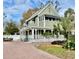 Charming two-story home with a wrap-around porch, mature landscaping, and a brick driveway at 6835 S Shamrock St, Tampa, FL 33616