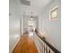 Hallway with hardwood floors, beadboard paneling, and stained glass window, creating a warm and stylish path at 6835 S Shamrock St, Tampa, FL 33616