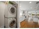 Spacious kitchen featuring hardwood floors, white cabinets and a stacked washer and dryer at 6835 S Shamrock St, Tampa, FL 33616