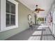 Relaxing front porch with comfortable seating, ceiling fan, and welcoming curb appeal at 6835 S Shamrock St, Tampa, FL 33616