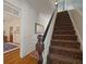 Staircase with custom designed stair runner, featuring natural light and wooden banister at 6835 S Shamrock St, Tampa, FL 33616