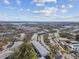 Aerial view of multiple condo buildings in a community with trees and a distant lake at 8425 112Th St # 104, Seminole, FL 33772