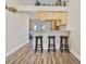 Kitchen featuring counter seating, wood floors, granite countertops, and stainless steel appliances at 913 Burlwood St, Brandon, FL 33511