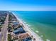 Panoramic aerial view of a coastal community, where beach homes line the pristine white sands at 920 Spruce Dr, Belleair Beach, FL 33786