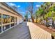 Expansive wooden deck leading to shed and bordered by lush tropical landscaping at 920 Spruce Dr, Belleair Beach, FL 33786