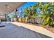 Spacious wooden back deck surrounded by tropical trees and a small backyard shed at 920 Spruce Dr, Belleair Beach, FL 33786