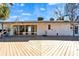 Backyard with a large wooden deck, a sliding glass door and ample sunlight at 920 Spruce Dr, Belleair Beach, FL 33786