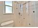 Bathroom with walk-in shower, white tiles, a toilet, and a window allowing natural light at 920 Spruce Dr, Belleair Beach, FL 33786