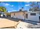 Exterior view of the home with a large wooden deck, pavers, and bright natural light at 920 Spruce Dr, Belleair Beach, FL 33786