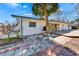 Exterior view of the home featuring a patio area with unique, colorful brickwork at 920 Spruce Dr, Belleair Beach, FL 33786
