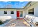 Inviting home front entrance features a bright red door, decorative lights and custom walkway at 920 Spruce Dr, Belleair Beach, FL 33786