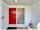 Welcoming front entrance featuring a red door, mosaic tile landing, and storm door at 920 Spruce Dr, Belleair Beach, FL 33786