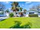 Inviting single-story home with a lush green lawn on a sunny day at 920 Spruce Dr, Belleair Beach, FL 33786