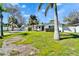 Charming home showcasing tropical landscaping, vibrant green lawn and a classic white fence at 920 Spruce Dr, Belleair Beach, FL 33786
