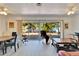 Expansive living room with sliding glass doors to deck, modern lighting, and dining area at 920 Spruce Dr, Belleair Beach, FL 33786