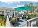 Enjoy outdoor living on the back deck with comfortable seating, shade umbrella, and lush tropical landscaping at 1015 Coldstream Ct, Tarpon Springs, FL 34689