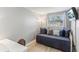 Comfortable bedroom with a cozy daybed, decorative pillows, a window with blinds, and a mounted TV at 1015 Coldstream Ct, Tarpon Springs, FL 34689