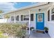 Inviting front porch featuring a blue door, well-maintained landscaping, and a welcoming entrance at 1015 Coldstream Ct, Tarpon Springs, FL 34689