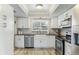 Updated kitchen features white cabinets, stainless steel appliances, and stylish tile backsplash at 1015 Coldstream Ct, Tarpon Springs, FL 34689