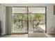 View from inside to the screened lanai with outdoor seating, a ceiling fan, and a view of the lush backyard at 12030 Steppingstone Blvd, Tampa, FL 33635