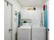 Functional laundry room equipped with a washing machine, dryer, storage cabinets, and shelving at 12030 Steppingstone Blvd, Tampa, FL 33635