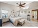 Serene main bedroom with a ceiling fan, a king-size bed, decorative accents, and access to an ensuite bathroom at 12030 Steppingstone Blvd, Tampa, FL 33635