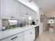 Bright kitchen featuring white cabinets, a tile backsplash, and stainless steel appliances at 1309 Hillside Dr, Tarpon Springs, FL 34689