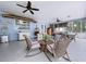 Covered patio featuring ceiling fans, wicker furniture seating arrangements and blue exterior at 1309 Hillside Dr, Tarpon Springs, FL 34689