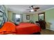 Inviting bedroom featuring a ceiling fan, natural light, and dark wood furniture at 1320 Bottlebrush Dr, Bradenton, FL 34208