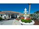 Charming clubhouse entrance with manicured landscaping, decorative fountain, and inviting pathway at 1320 Bottlebrush Dr, Bradenton, FL 34208