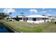 Waterfront home featuring lush landscaping and charming shutters at 1320 Bottlebrush Dr, Bradenton, FL 34208