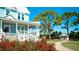 Charming blue home with a white porch, a red bush, a gazebo and mature trees, set back from the road at 1320 Bottlebrush Dr, Bradenton, FL 34208
