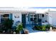 Charming home entrance featuring a lovely turquoise door, shuttered windows, and beautiful landscaping at 1320 Bottlebrush Dr, Bradenton, FL 34208
