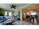 Spacious living area featuring an open floor plan with a ceiling fan and seamless flow to dining area at 1320 Bottlebrush Dr, Bradenton, FL 34208