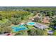 Expansive aerial view of the community's pool, tennis courts, and surrounding homes and greenery at 13439 Norman Cir, Hudson, FL 34669