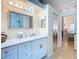 Bright bathroom features a large mirror, white cabinets, and access to the bedroom at 13439 Norman Cir, Hudson, FL 34669