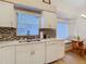 Well-lit kitchen featuring white cabinetry, stainless steel appliances, and breakfast nook at 13439 Norman Cir, Hudson, FL 34669