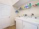 Functional laundry room with washer, dryer, utility sink, and storage shelves at 13439 Norman Cir, Hudson, FL 34669
