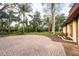 Spacious backyard featuring a circular brick area and lush, mature landscaping at 14333 Lake Magdalene Blvd, Tampa, FL 33618