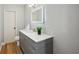 Well-lit bathroom with a gray vanity, white countertop, and modern illuminated mirror at 14333 Lake Magdalene Blvd, Tampa, FL 33618